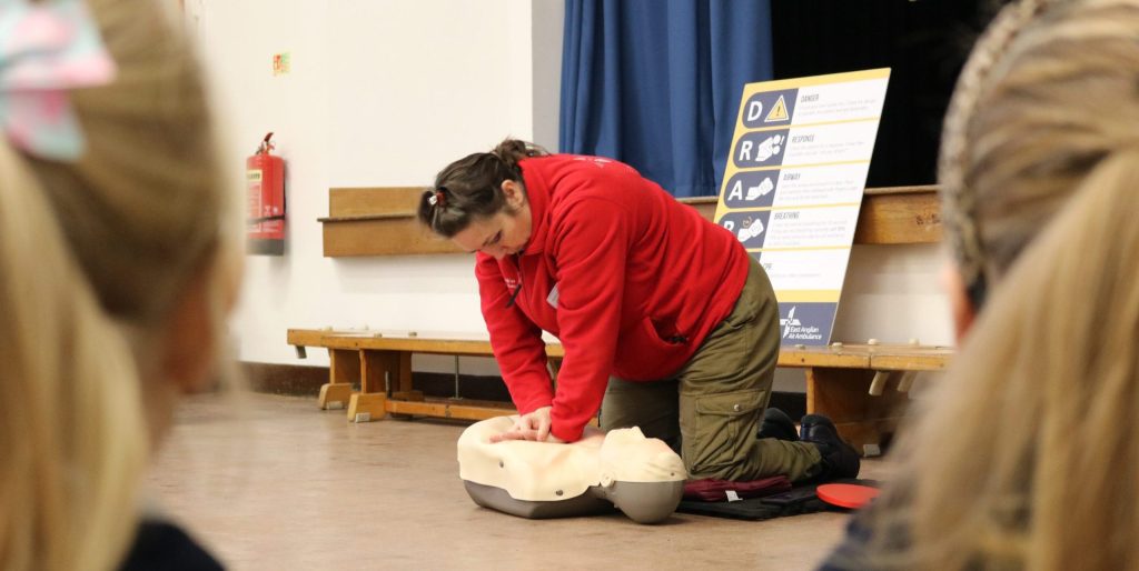 EAAA Volunteer showing people how to do CCPR chest compressions