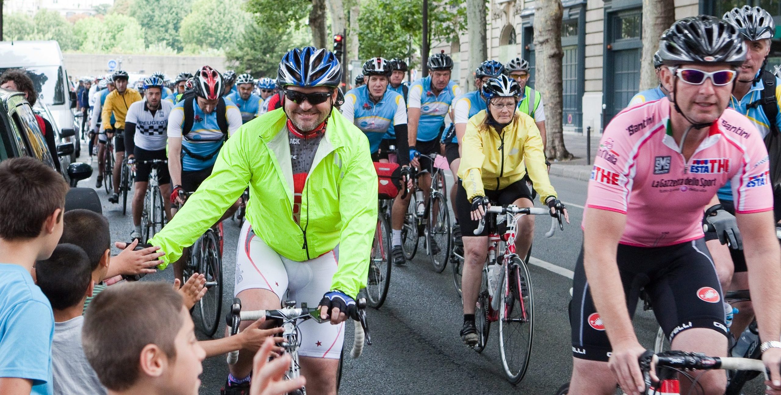 Man high fiving crowd on London to Paris cycle